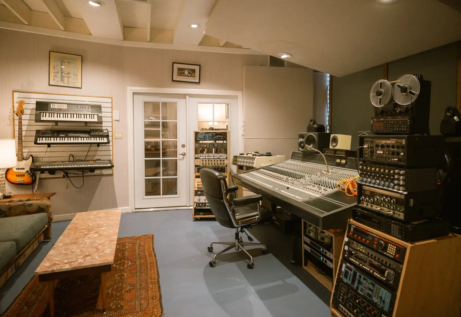 Wide view of the Honeymoon Suite control room with the Neotek console, tape machine, racks, and couch